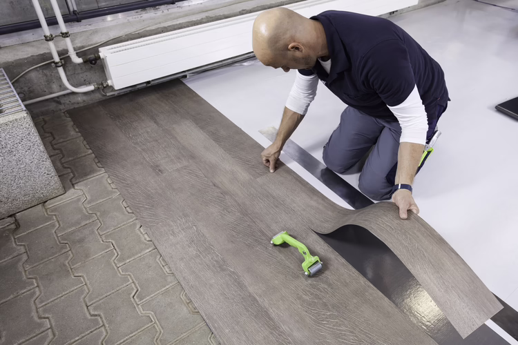 Without bending, install the planks or tiles along the reference line and press down firmly by hand. Keep pulling back the protective paper. Apply the floor covering bit by bit as described previously and roll over with the WOLFF Duo pressure roller.