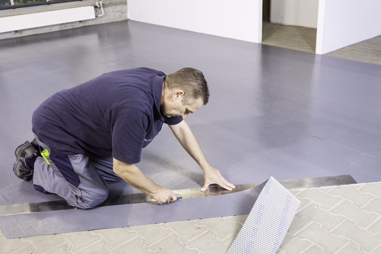 Roll out and precut the reinforcement underlay. Against all vertical structures leave a gap of at least 3 to 10 mm, depending on the floor covering and load. The side of the seams between the sheets do not need to be cut.