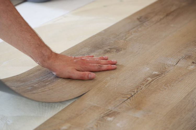 Within the short open time, lay the LVT along the positioning line and rub down by hand. Then thoroughly roll over the area with the WOLFF pressure roller.